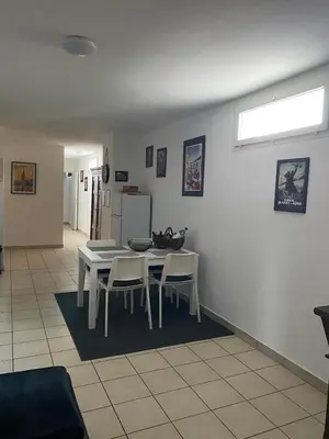 a dining room with a white table and chairs at Agréable rez de jardin avec Piscine et Jacuzzi in Cervione