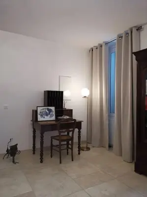 a room with a table and a chair and a window at CHEZ PERLE à LEVIE, logement entier de type T4 in Levie