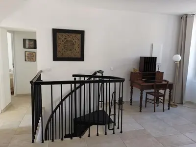 a room with a staircase and a table and a desk at CHEZ PERLE à LEVIE, logement entier de type T4 in Levie