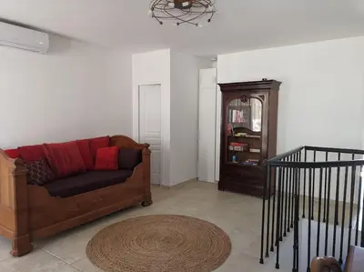 a living room with a couch and a book shelf at CHEZ PERLE à LEVIE, logement entier de type T4 in Levie
