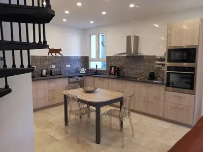 a kitchen with a table and chairs in a kitchen at CHEZ PERLE à LEVIE, logement entier de type T4 in Levie