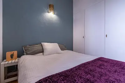 a bedroom with a bed with a purple blanket at Le Golfe d'Ajaccio - à 7 minutes de la plage in Grosseto-Prugna