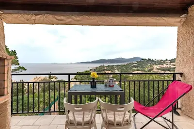 a patio with a table and chairs on a balcony at Le Golfe d'Ajaccio - à 7 minutes de la plage in Grosseto-Prugna