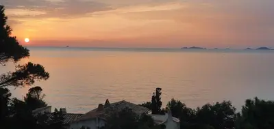a sunset over the water with houses in the foreground at Le Golfe d'Ajaccio - à 7 minutes de la plage in Grosseto-Prugna