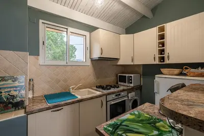 a kitchen with a sink and a stove top oven at Le Golfe d'Ajaccio - à 7 minutes de la plage in Grosseto-Prugna
