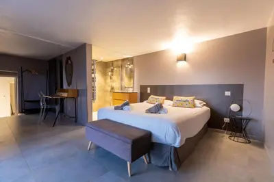 a bedroom with a large bed and a table at Villa Kallisté piscine chauffée in Serra-di-Ferro