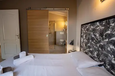 a bedroom with a large white bed and a bathroom at Villa Kallisté piscine chauffée in Serra-di-Ferro