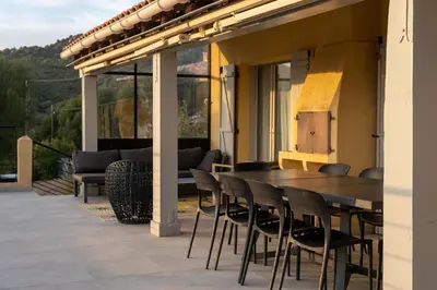 a wooden table and chairs on a patio at Villa Kallisté piscine chauffée in Serra-di-Ferro