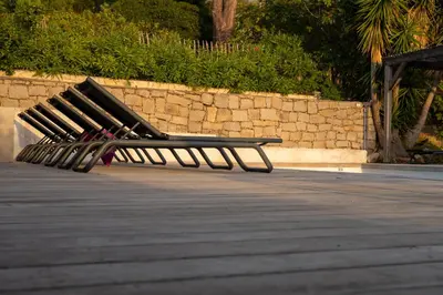 a bench sitting on a sidewalk next to a wall at Villa Kallisté piscine chauffée in Serra-di-Ferro