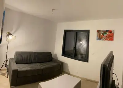 a living room with a brown couch and a window at Villa Pacienta in Bonifacio