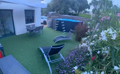 a yard with chairs and a table and some flowers at Villa Pacienta in Bonifacio