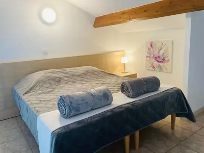 a bedroom with a bed with blue pillows on it at Bel appartement dans résidence avec piscine in Linguizzetta