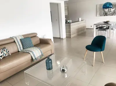 a living room with a couch and a glass table at SUPERBE APPARTEMENT SUR PLAGE VUE PARADISIAQUE PIEDS DANS L'EAU in Propriano