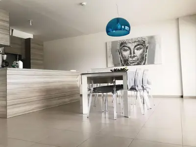 a kitchen with a table and chairs in a room at SUPERBE APPARTEMENT SUR PLAGE VUE PARADISIAQUE PIEDS DANS L'EAU in Propriano