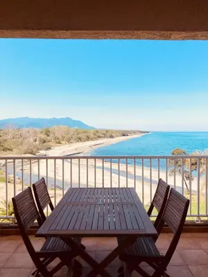 a table and chairs on a balcony with the beach at Punta di Mare in Linguizzetta