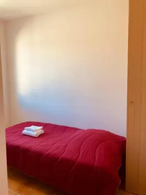 a red bed with two towels on top of it at Punta di Mare in Linguizzetta