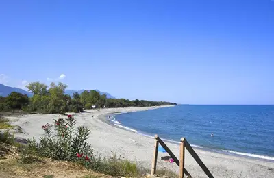 a beach with a wooden fence next to the water at Punta di Mare in Linguizzetta