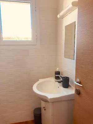a white bathroom with a sink and a window at Punta di Mare in Linguizzetta