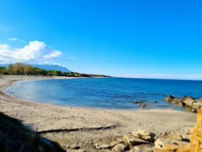 a beach with rocks and the ocean on a sunny day at Punta di Mare in Linguizzetta
