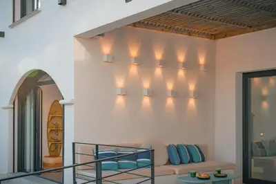 a living room with a couch and lights on the wall at Villa Blue Pearl 10 pers piscine chauffée 10 minutes plage à pieds in Sainte-Lucie de Porto-Vecchio
