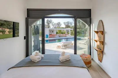 a bedroom with a bed with two towels on it at Villa Blue Pearl 10 pers piscine chauffée 10 minutes plage à pieds in Sainte-Lucie de Porto-Vecchio