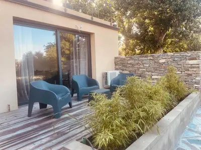a patio with blue chairs on a wooden deck at T3 dans charmante propriété in Borgo