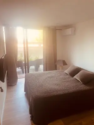 a bedroom with a bed and a large window at T3 dans charmante propriété in Borgo
