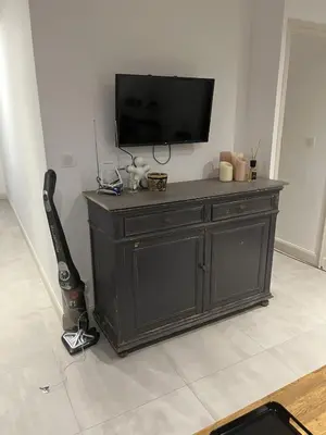a black entertainment center with a flat screen tv on a wall at T3 dans charmante propriété in Borgo