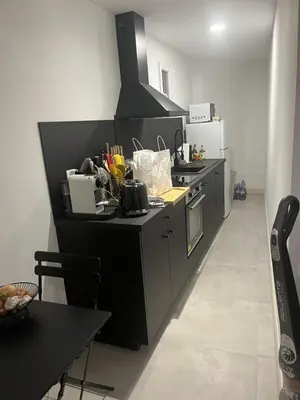 a kitchen with a black counter top with a stove at T3 dans charmante propriété in Borgo