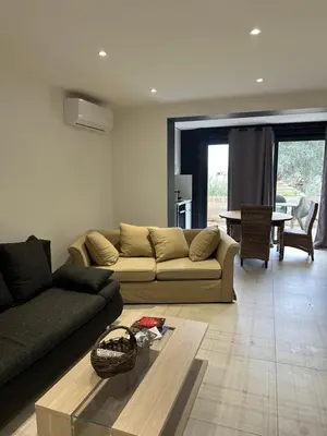 a living room with a couch and a table at Charmante Propriété Arborée in Borgo