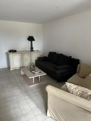 a living room with a black couch and a table at Charmante Propriété Arborée in Borgo