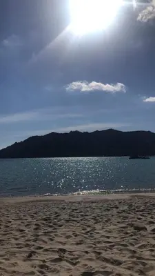 a beach with the sun shining over the water at Mini villa proche des plus belles plages in Porto-Vecchio