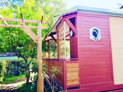 a red out house with a wooden structure at Beach house à Marina di Sorbo …Corse in Sorbo-Ocagnano