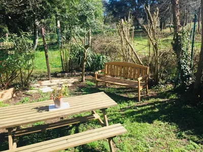 two wooden benches sitting in the grass with a table at Beach house à Marina di Sorbo …Corse in Sorbo-Ocagnano