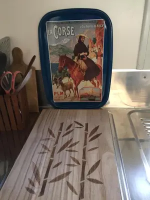 a suitcase sitting on a table with a poster of a man riding a horse at Beach house à Marina di Sorbo …Corse in Sorbo-Ocagnano