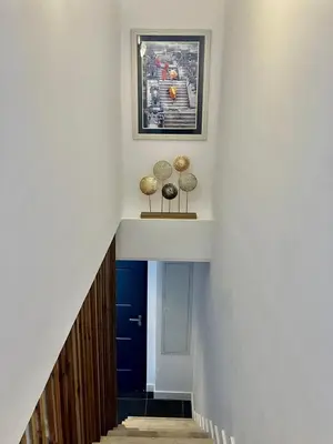 a hallway with a white wall and a blue door at tytoun evasion in Borgo