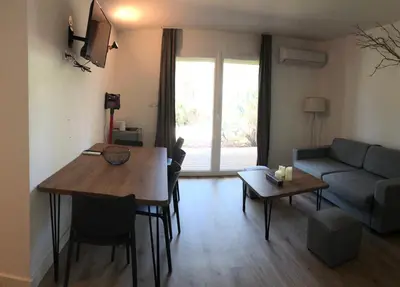 a living room with a table and a couch at Résidence Fiori di Cala Rossa in Lecci