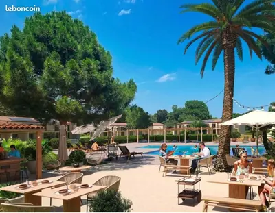 a group of people sitting at tables by a pool at Résidence Fiori di Cala Rossa in Lecci