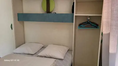 a bunk bed with two pillows in a room at Chalet climatisé avec patio en Haute Corse 5 couchages in Camp du Cap Sud