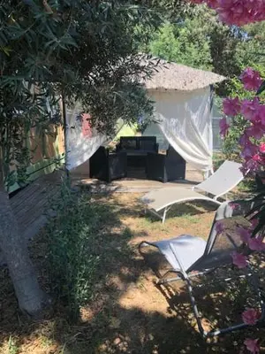 a couple of chairs sitting in a yard with a house at Chalet climatisé avec patio en Haute Corse 5 couchages in Camp du Cap Sud