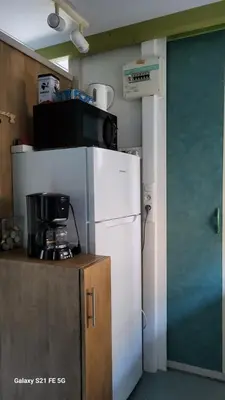 a kitchen with a white refrigerator and a microwave at Chalet climatisé avec patio en Haute Corse 5 couchages in Camp du Cap Sud