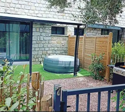 a backyard with a hot tub in the grass at N7 Maison T2 climatisé avec jacuzzi privé in Ajaccio