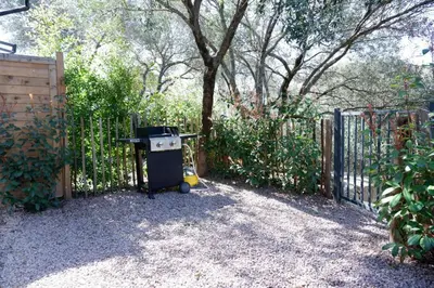 a gate with a trash can in front of a fence at N7 Maison T2 climatisé avec jacuzzi privé in Ajaccio