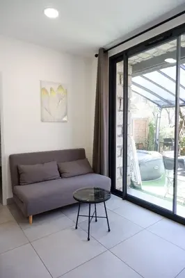 a living room with a couch and a glass table at N7 Maison T2 climatisé avec jacuzzi privé in Ajaccio