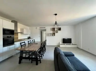a kitchen and dining room with a table and a couch at Les Hauts du Port-Appartement neuf sur le port in Bonifacio