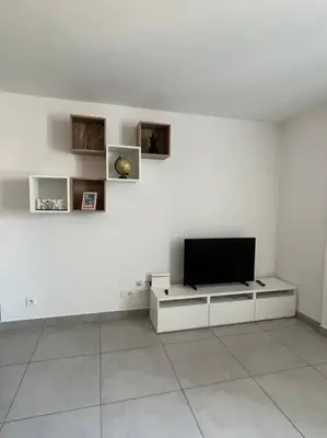 a living room with a tv on a white wall at Les Hauts du Port-Appartement neuf sur le port in Bonifacio