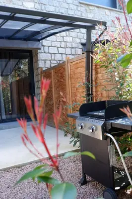 a barbecue grill in a garden with a fence at N8 Maison T2 climatisé in Ajaccio