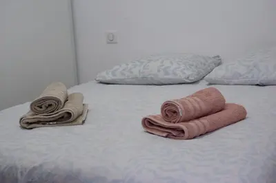a bed with two towels and pillows on it at N8 Maison T2 climatisé in Ajaccio