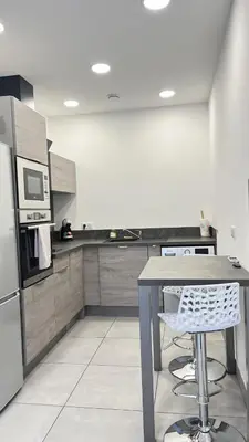 a kitchen with a table and a refrigerator at N8 Maison T2 climatisé in Ajaccio