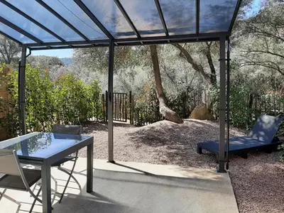 a gazebo with a table and a blue table and a chair at N9 Maison T2 climatisé in Ajaccio